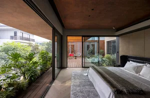 A modern bedroom with a balcony featuring plants and a wooden deck.