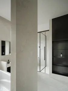Modern concrete bathroom with minimalist design, featuring white walls and black accents.
