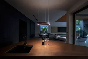 A modern kitchen with a concrete countertop and a black sink.