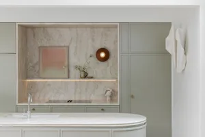 An elegant, minimalist kitchen featuring a marble countertop and backsplash with soft lighting and subtle decorative elements