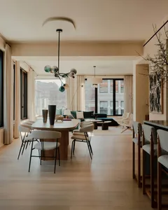 Modern living room with wood flooring, fabric furniture, glass elements, and metal accents.