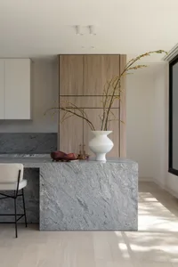 A modern minimalist kitchen with a granite countertop, featuring sleek cabinetry and minimalist design elements.