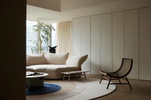 A modern living room with a neutral-toned color palette, featuring a contemporary sofa, minimalist coffee table, and a natura