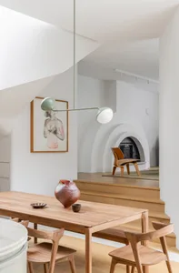 Modern residential dining room with wooden table, chairs, and minimalist decor.