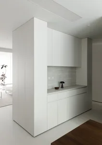 A minimalist residential kitchen featuring concrete countertops and cabinets.
