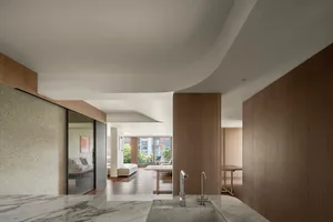 Modern apartment interior with marble walls and wood cabinets, featuring clean lines and contemporary design elements.
