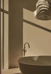 Modern bathroom featuring a sleek, ceramic free-standing tub with a minimalist design and natural light streaming through the