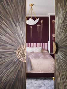 Modern bedroom with a textured fabric wall, a comfortable bed, and decorative elements.