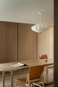 Modern dining room with wooden furnishings and a geometric pendant light.