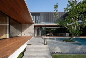 Modern house exterior with concrete walls and wooden deck.