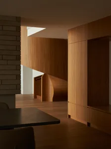 Modern residential interior with wooden elements and a spiral staircase.
