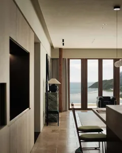 Modern living room featuring ocean views with wooden flooring, steel accents, and marble finishes.