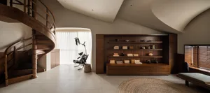A modern residential library featuring wooden shelves and furniture.