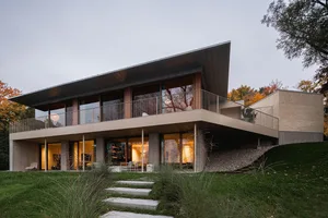 Modern residential architecture with metallic roof and large windows.