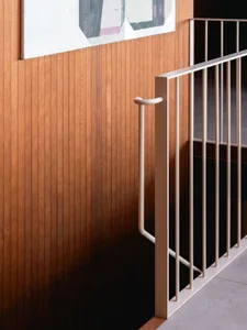 A modern stair railing with white metal balusters and wooden panels.