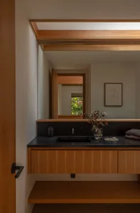 A minimalist bathroom featuring wooden cabinets and a granite countertop.