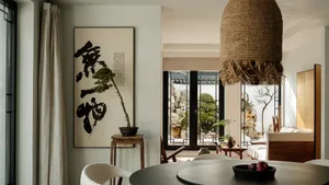 A minimalist living room featuring wood and bamboo furniture, with a view of a serene garden.