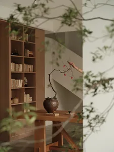 A minimalist living space featuring wooden furniture and a potted plant on a wooden table.