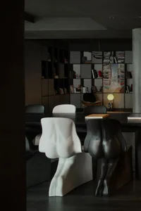A modern dining room with black metal furniture and a black table.