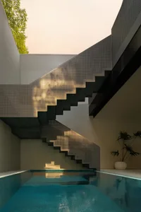 Concrete stairs with perforated metal tread in a modern interior setting.