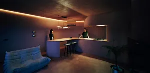A modern kitchen with a wooden counter illuminated by ambient lighting.