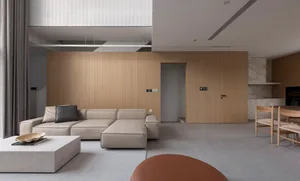 Modern minimalist living room featuring a concrete floor, a wooden wall, and a comfortable beige sectional sofa with a black 