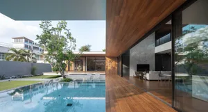 Modern minimalist residential interior featuring wooden floors, glass walls, and marble accents.
