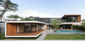 Modern residential exterior featuring wood, glass, and stone materials