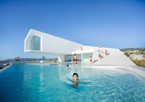 A modern residential house with a glass swimming pool.