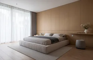 Modern minimalist bedroom with a wooden platform bed, grey bedding, and large windows with sheer curtains.