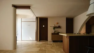 A minimalist residential kitchen with wooden finishes and a modern design.