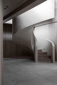 Modern, sleek, concrete staircase with a fluid, curved design.