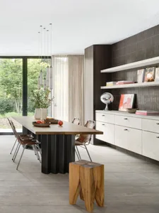 A modern dining area featuring a wooden table, concrete pillars, and a concrete floor with a large window.