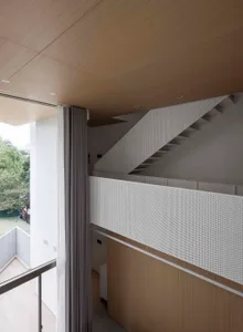 A modern interior space featuring metallic perforated panels and wooden elements.