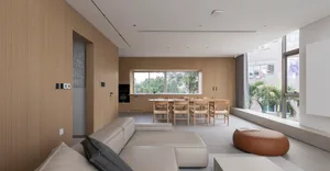 Modern living room, dining area, and kitchen with wooden materials and clean lines.