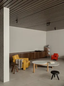 Contemporary living room featuring modern furniture, including yellow and red leather armchairs, a round marble-top coffee ta