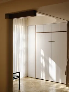 Modern minimalist interior with white cabinets and sheer curtains.