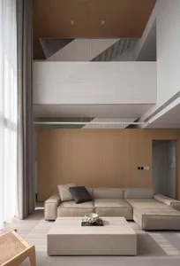 A modern minimalist living room with neutral-toned leather furniture and a minimalist coffee table.