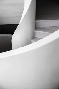 A modern minimalist staircase featuring concrete steps and a white wall.