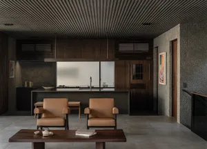 A modern, minimalist residential kitchen with concrete countertops and walls.