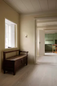 A minimalist interior featuring wood and plaster materials.
