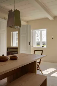 A minimalist interior design featuring a wooden table with three bowls on it.