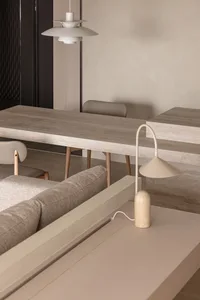 Modern dining room featuring minimalist concrete furniture and sleek, neutral tones.