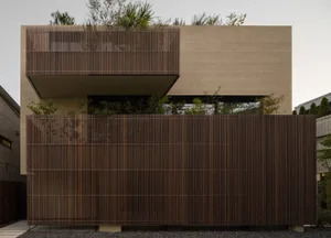 A modern house exterior featuring a wood slat fence and greenery.