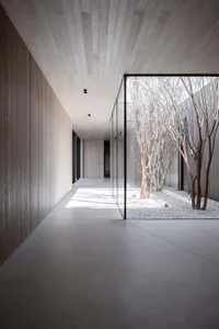 Minimalist interior with concrete flooring, glass walls, and white walls