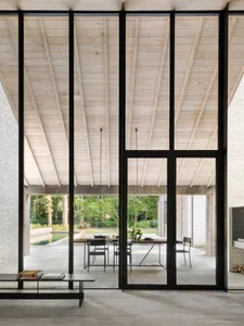 Contemporary indoor living space with modern furniture and large glass windows.