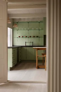 A modern minimalist kitchen with wooden cabinets, glass shelves, and a marble countertop.