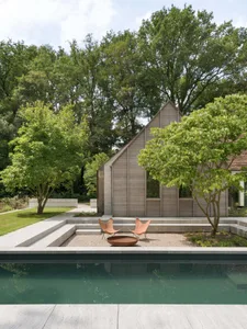 An outdoor residential space featuring a modern wooden exterior and a pool.