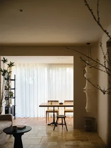 A modern residential interior with wooden furniture and a large window.