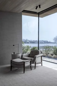 A modern living room with a minimalist design featuring a neutral color palette, featuring comfortable seating and a view of